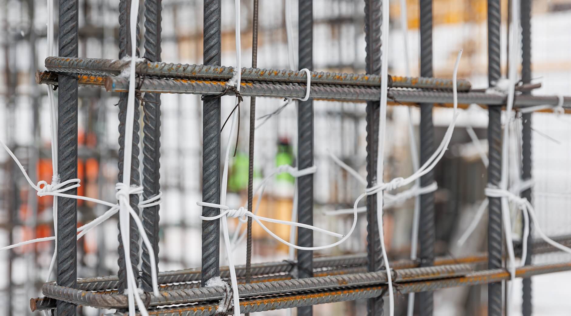 Close-up of steel rebar framework tied together with wire at a construction site.